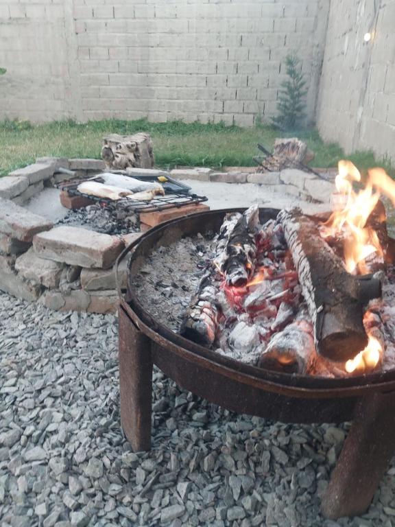 a fire pit with a grill with flames in it at La posadita sp in San Pedro