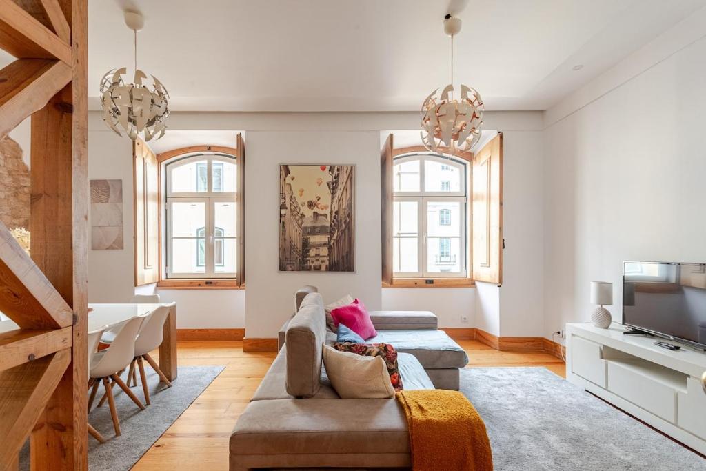 a living room with a couch and a tv at Cais Sodré Spacious Apartment in Lisbon