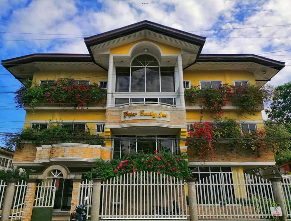 a yellow house with flower boxes on the front of it at Paper Country Inn in Mangagoy