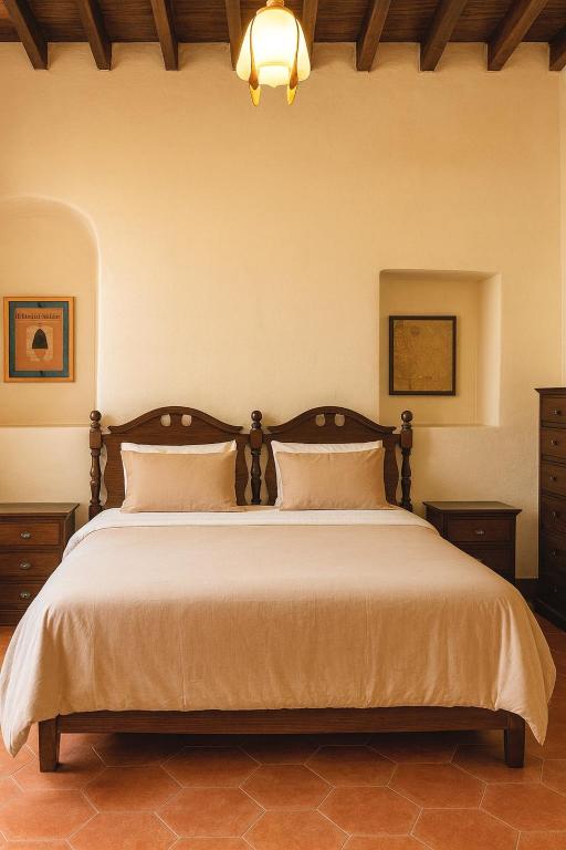 a bedroom with a large bed with two pillows at Casa Centenario in Taxco de Alarcón