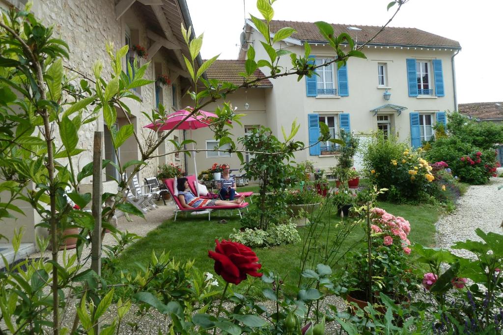 um jardim em frente a uma casa com flores em Les chambres d'hôtes Joy em Val de Vesle