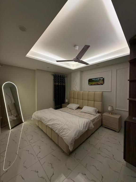 a bedroom with a bed and a ceiling fan at Elite Corners Luxury 2BR Apartment The Gate Mall Faisal Town in Barkat