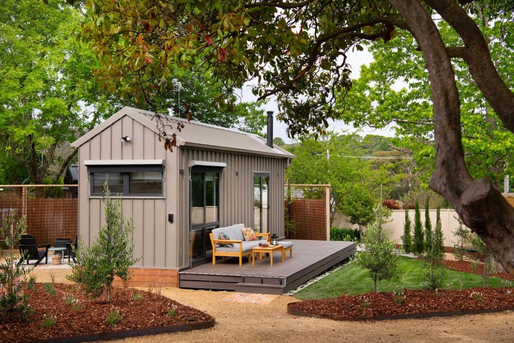 a small shed with a table and a chair at Piccola Verde Tiny House in Hepburn