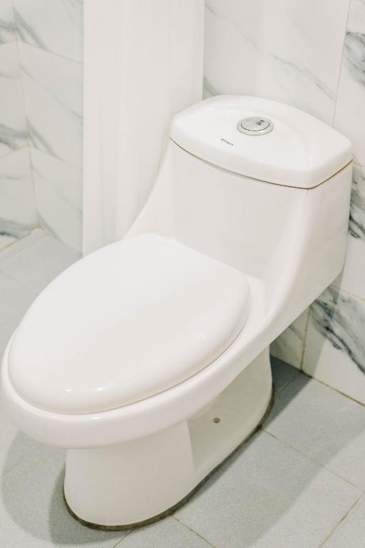 a white toilet sitting in a bathroom stall at Casa de Oro in Iyam