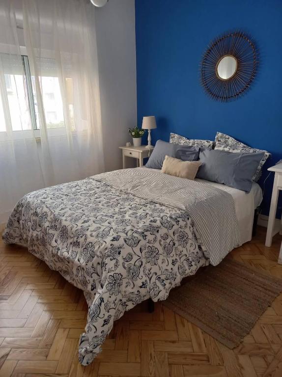 a bedroom with a large bed with a blue wall at Blue House - two rooms in Almada