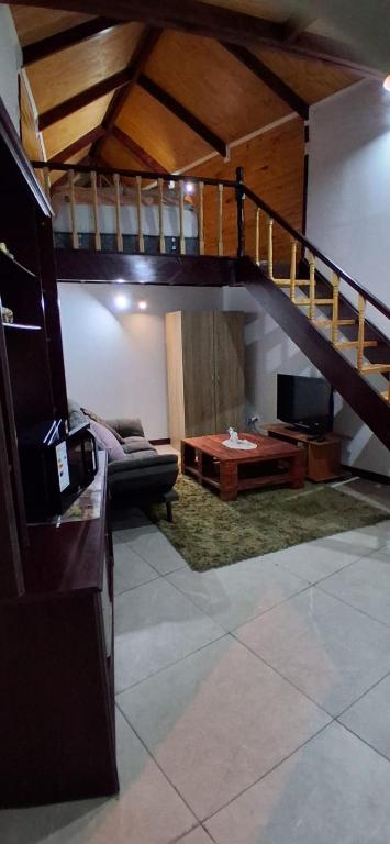 a living room with a couch and a staircase at Departamento Interior independiente in Coquimbo