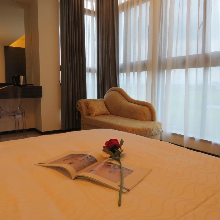 a book with a rose on top of a bed at Grand Allevia Villa in Wujie