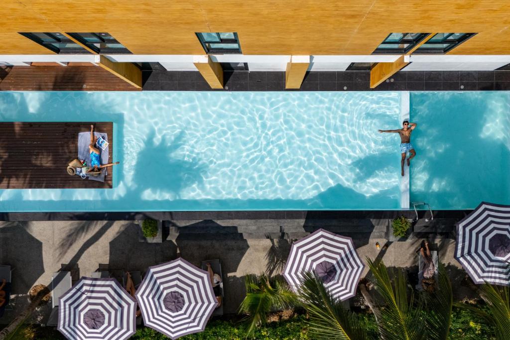 an overhead view of a swimming pool with umbrellas at Book a Bed Poshtel - SHA Plus in Phuket