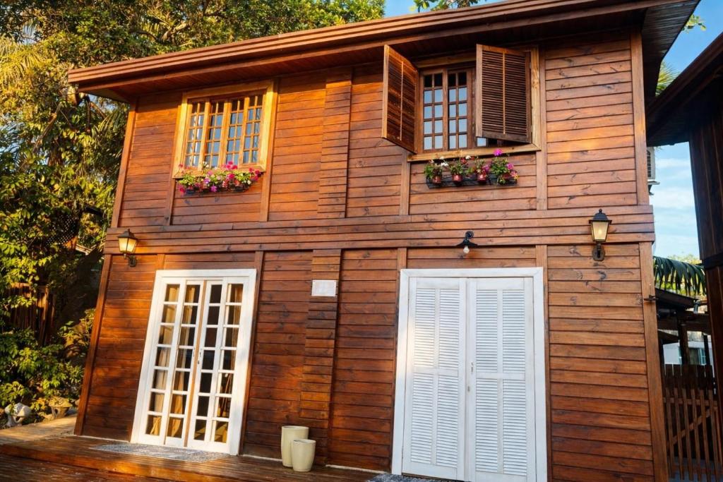 a wooden house with white doors and windows at Vilarejo Hospedagem - Encantadas in Ilha do Mel