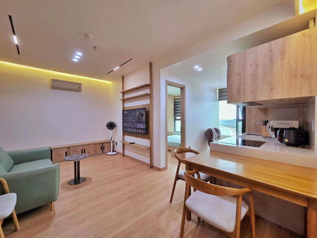 a kitchen and living room with a table and chairs at Little House Sea in Nha Trang