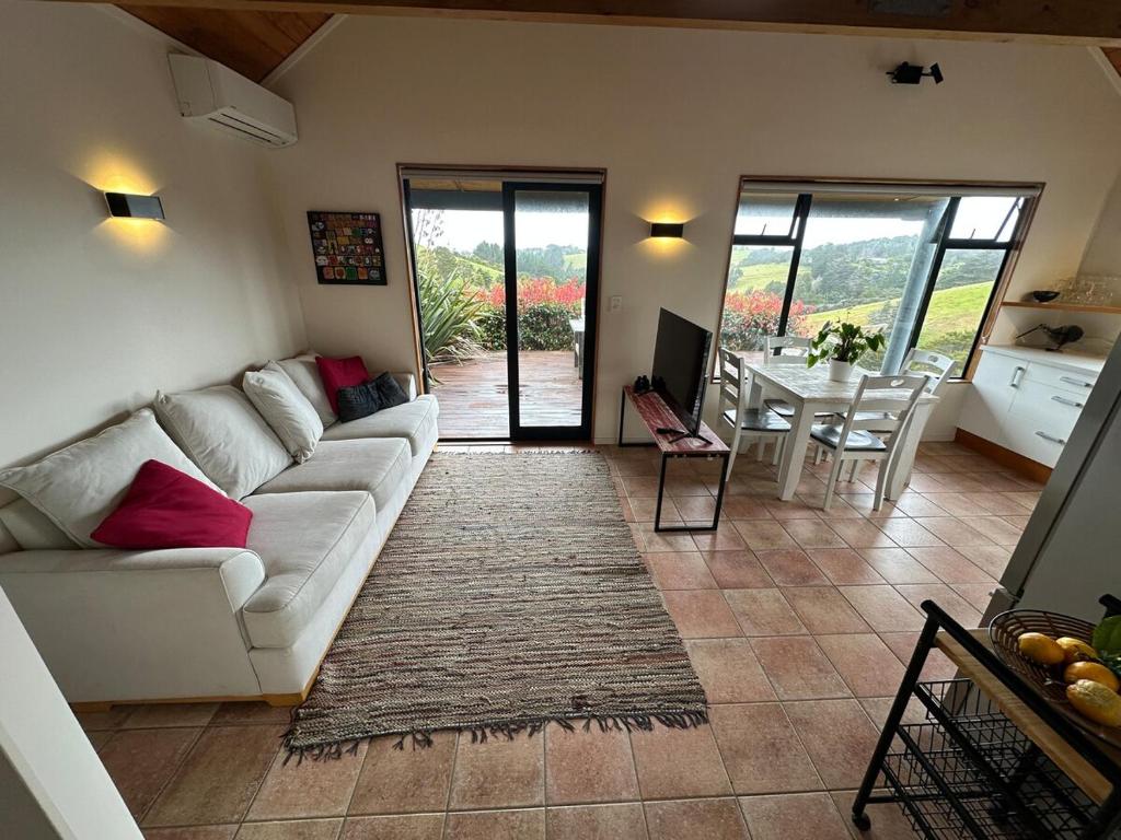 a living room with a white couch and a table at Matapouri Sanctuary Apartment in Matapouri