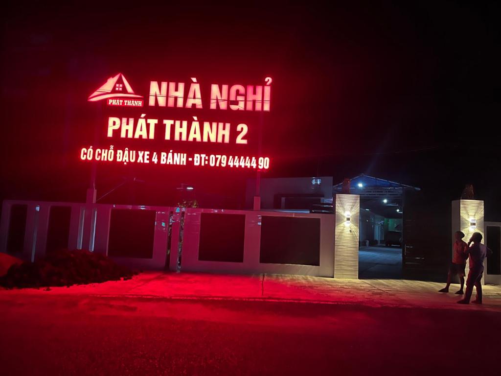 two people standing in front of a building at night at nhà nhỉ phát thành in Kon Rung (1)