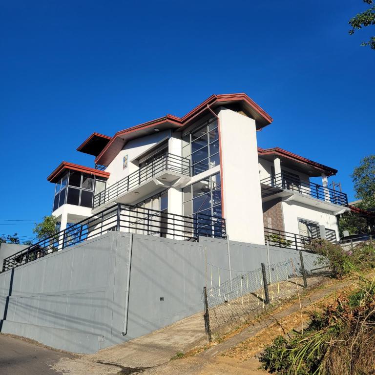 a white building with balconies on top of a fence at Hatton Nottingham Villa in Hatton