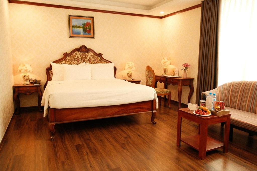 a hotel room with a bed and a couch at The Vissai Hotel in Ninh Binh