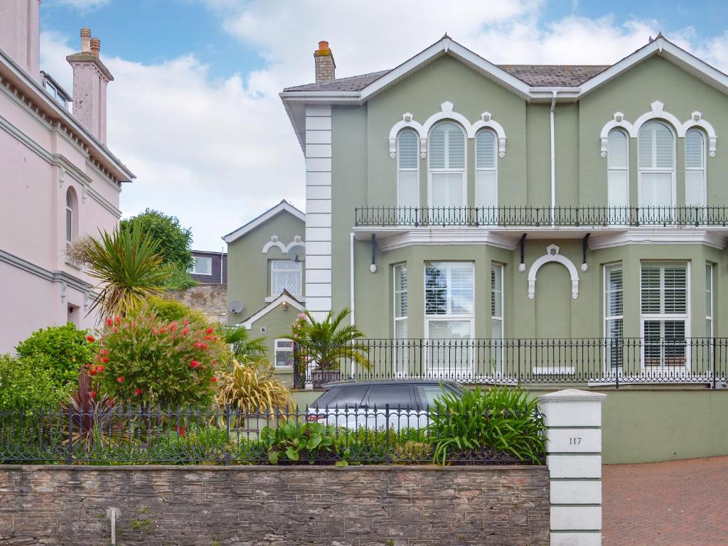 a house with a fence in front of it at Samphire Lodge in Brixham