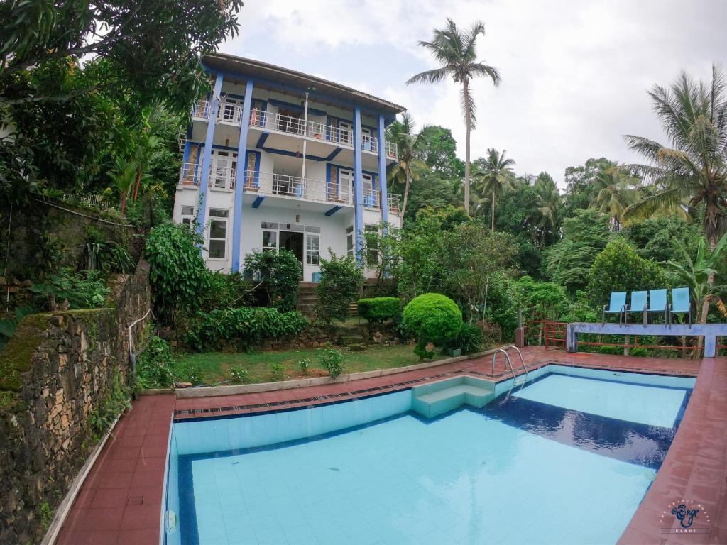 a swimming pool in front of a house at The Change Hotel in Kandy