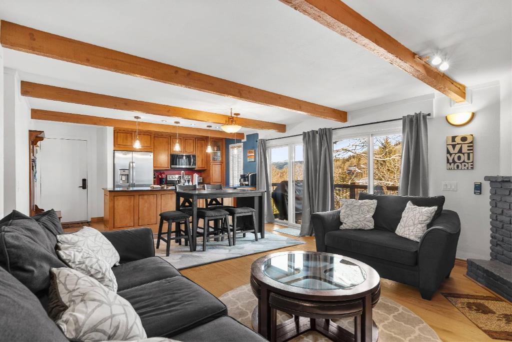 a living room with a couch and a table at Woodbridge 21C in Snowmass Village