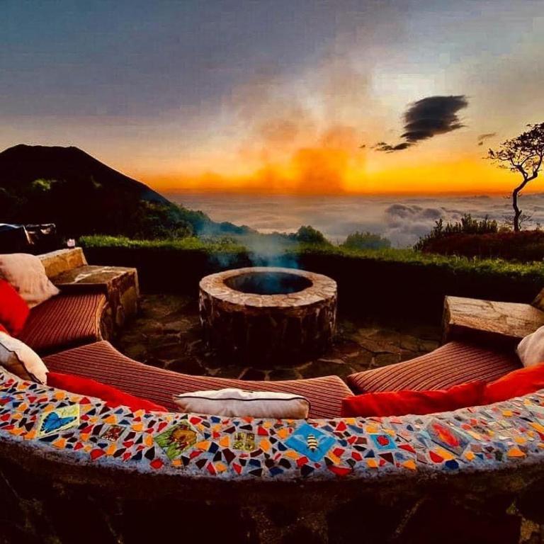 a painting of a fire pit with a sunset in the background at Sueño Verde EcoVilla in Cerro Verde