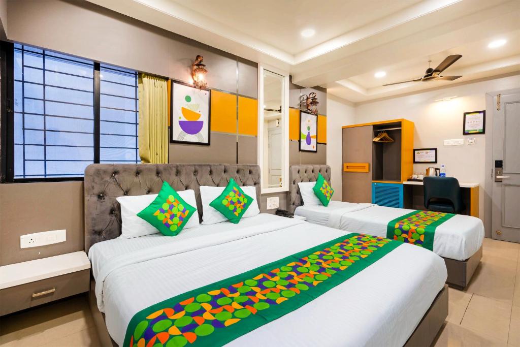 a hotel room with two beds and a desk at Treebo Aurum Leaf in Nagpur