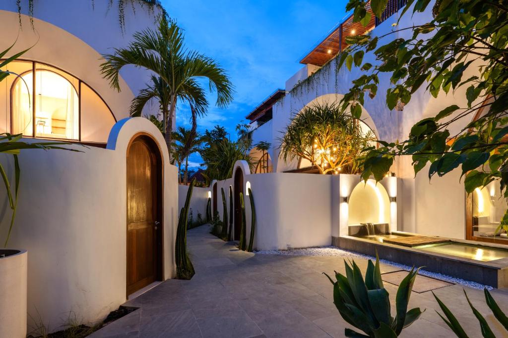 an exterior view of a villa with palm trees at Suasana by AYA in Uluwatu