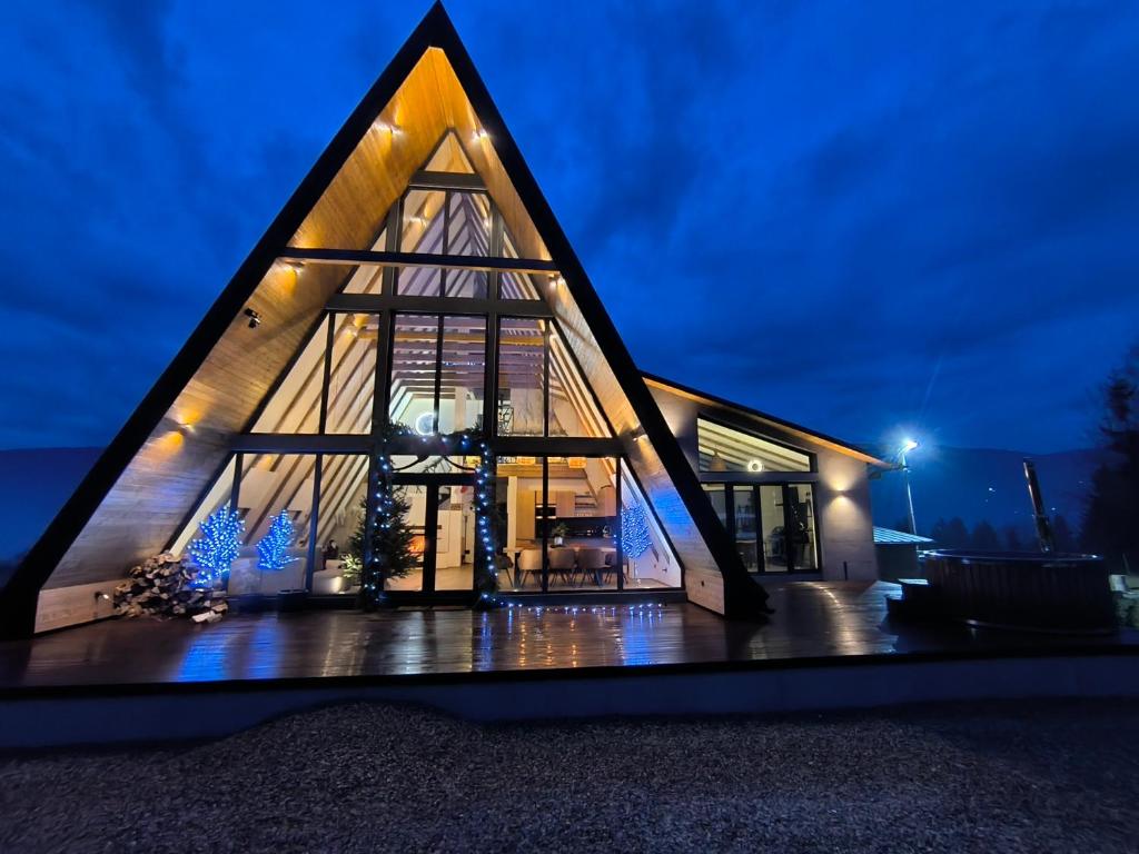 a pyramid shaped house with a glass facade at night at Chalet Rafenstein in Moisei
