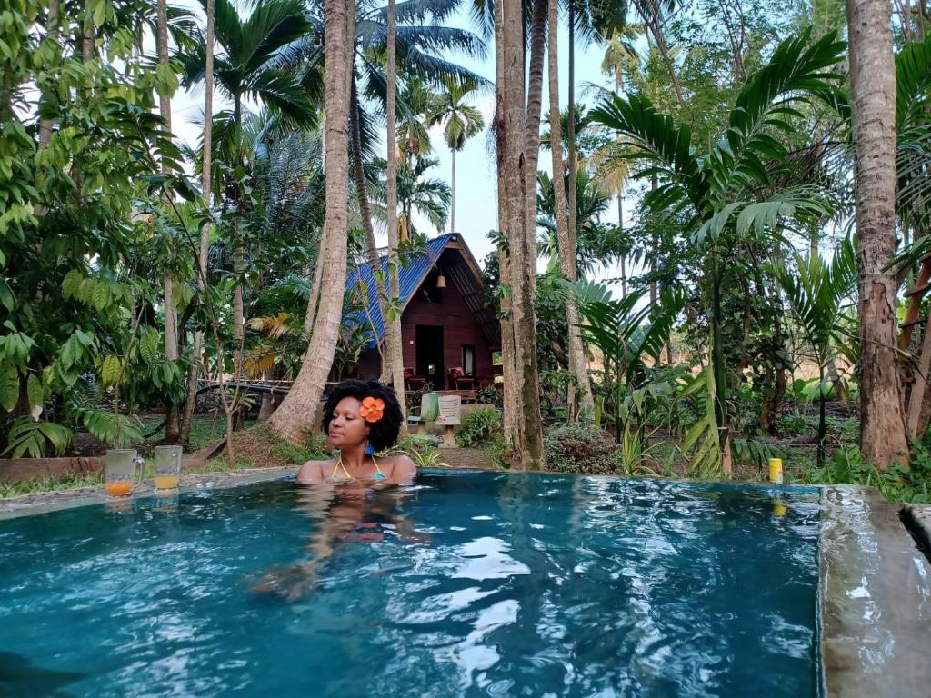 a woman in a swimming pool in a resort at Brooklyne Jungle Nest in Udawalawe