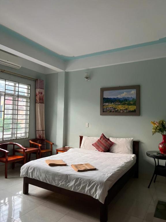 a bedroom with a large bed with white sheets at Sunshine Loop Hostel in Làng Lap