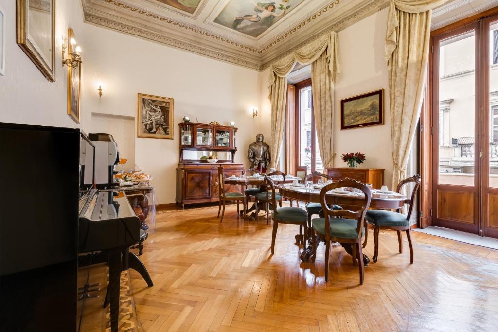 una sala da pranzo con tavolo e sedie di Affreschi Su Roma Luxury B&B a Roma