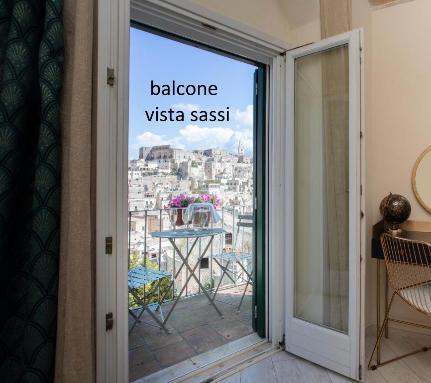 a door to a balcony with a view of a city at Lo Scorcio, casa vacanza nel cuore dei Sassi con vista incantevole con Self check-in in Matera
