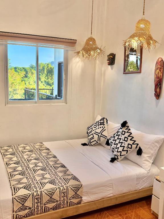 a bedroom with a bed with two pillows on it at Brisa Room T in El Nido Airport