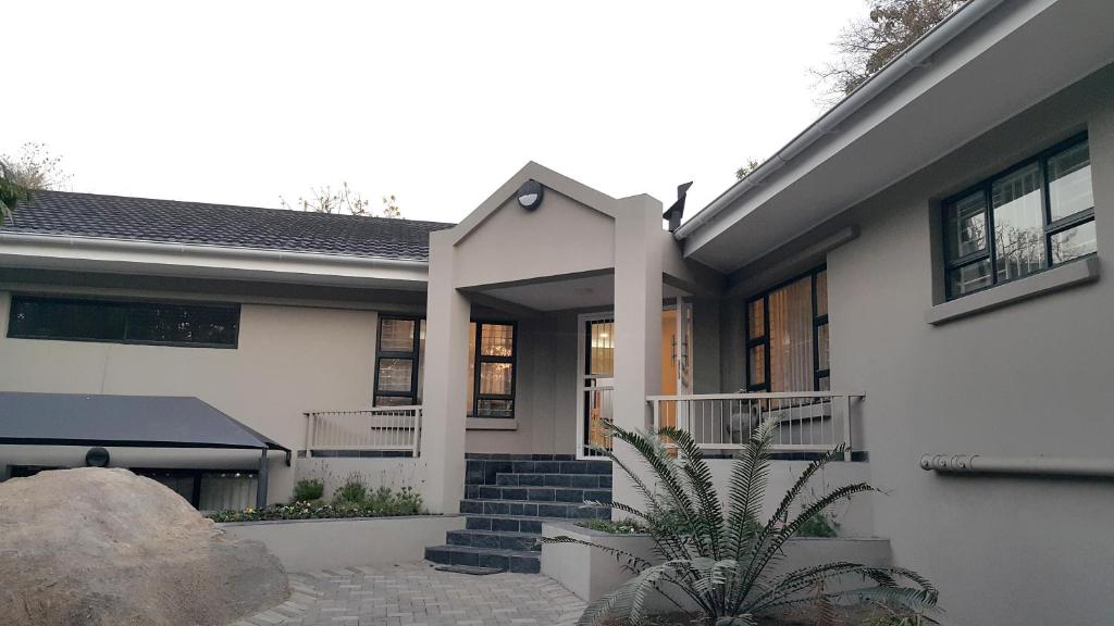 a white house with a staircase in front of it at Vineyard On The Hill in Nelspruit