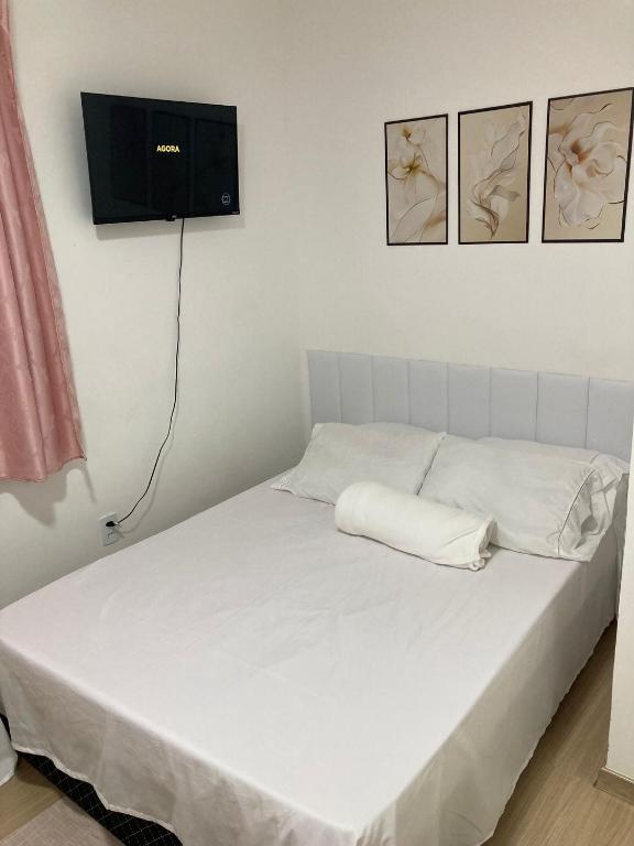 a white bed with a television on the wall at Hostel Vibes in Rio de Janeiro