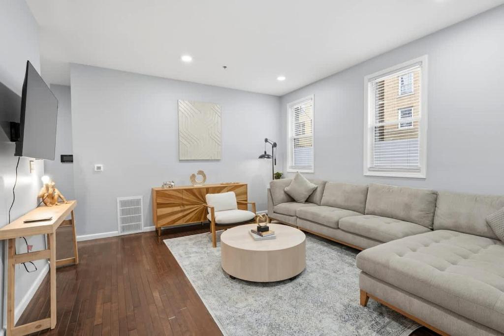a living room with a couch and a table at Spacious 3BR 2BA Apt with Private Parking Walk to PATH in Jersey City