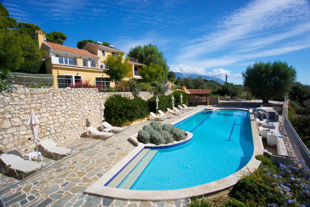 a swimming pool in front of a villa at Villa Theodora in Lakíthra