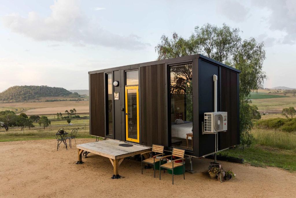ein kleines schwarzes Haus, das auf einem Feld steht in der Unterkunft Greenmount by Tiny Away in Greenmount