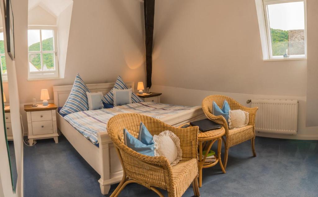 a bedroom with a bed with chairs and a table at Weingut Herrenhof Andrea Thielen in Minheim