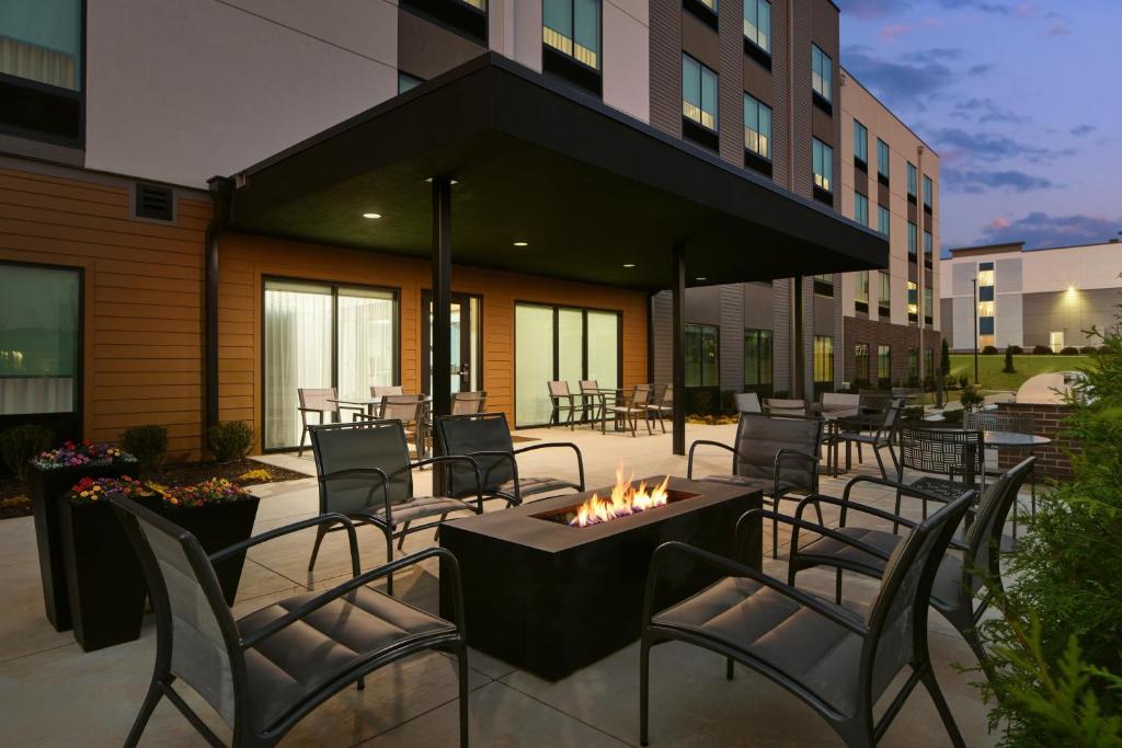 a patio with chairs and a fire pit in front of a building at Hyatt Studios Huntsville in Huntsville