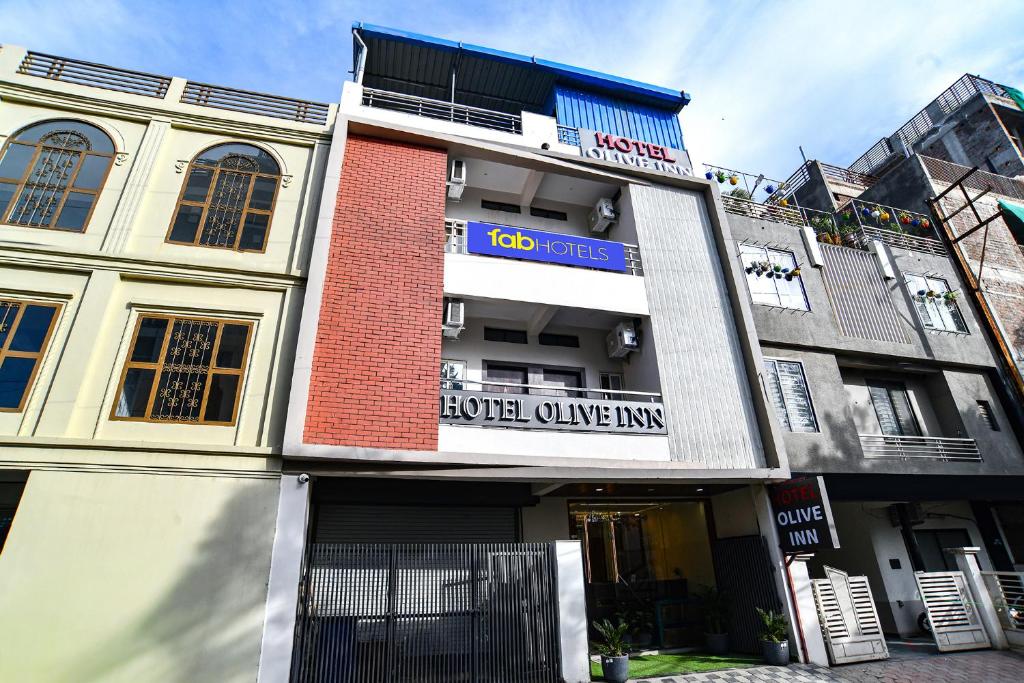 a building with a sign that reads liquor alive inn at FabHotel Olive Inn in Indore
