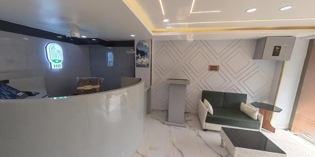 a lobby with a couch and a sign on a wall at Happy Residency in Patna