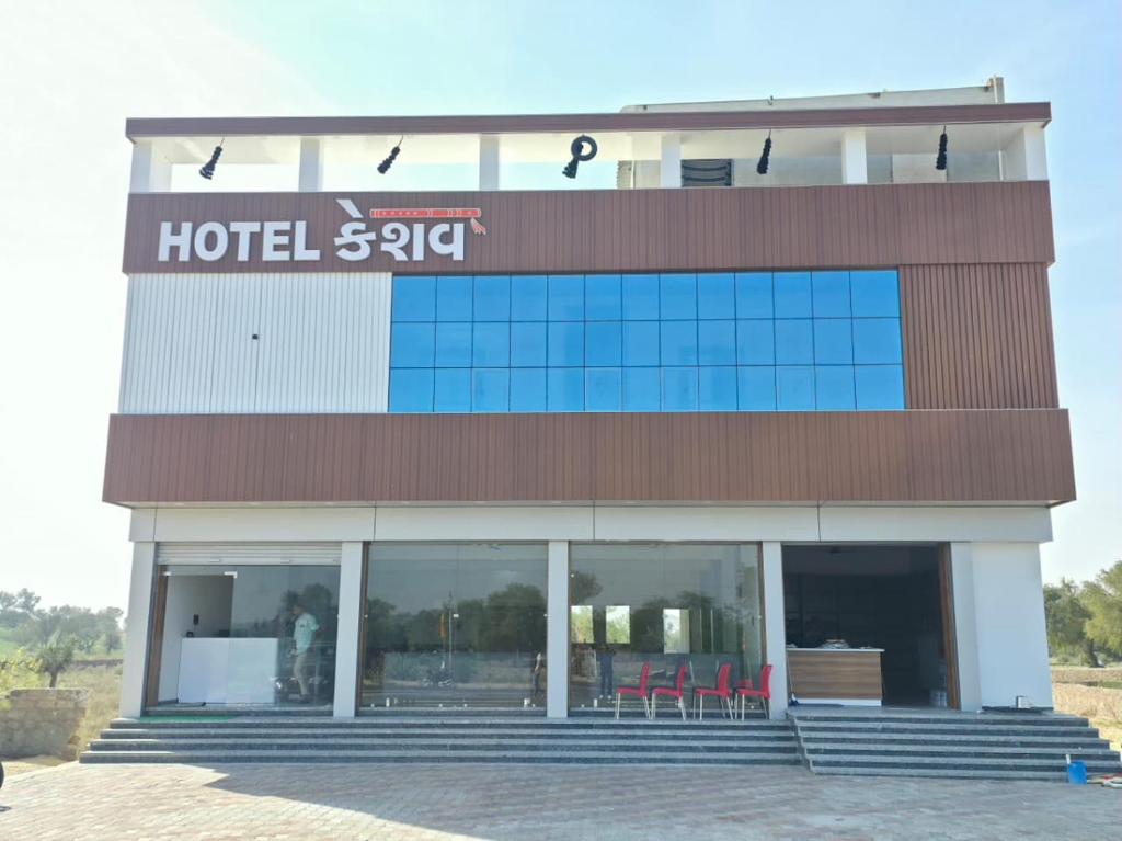 a hotel with chairs in front of a building at Hotel Keshav in Dhorīmanna