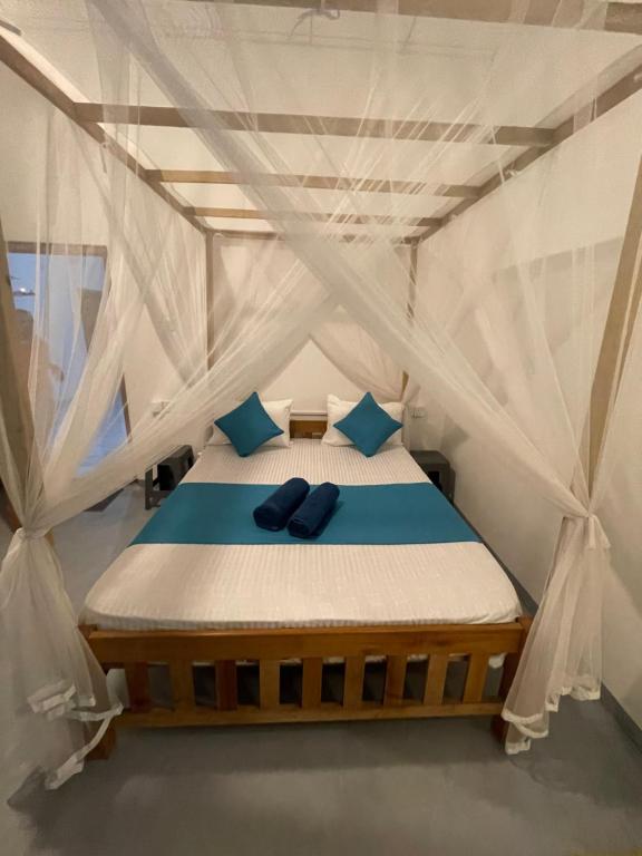 a bed in a tent with blue pillows on it at Dew home stay in Dickwella