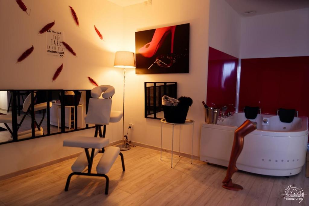 a living room with chairs and a table and a lamp at LoveRoom Les Folies Douces & Spa in Nancy
