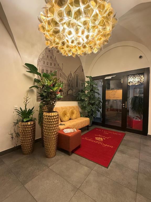 a living room with a couch and a chandelier at Hotel Schwibbogen Altstadt & Apartments in Görlitz