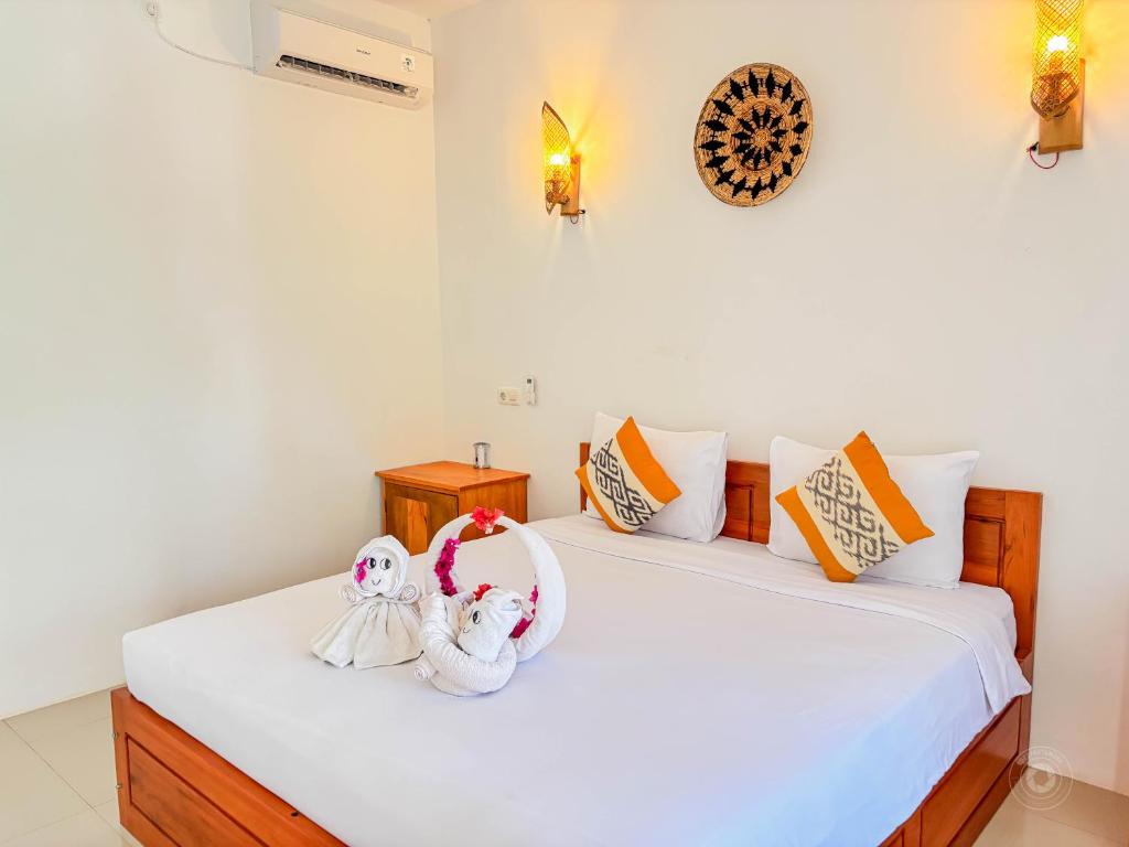 two stuffed animals are sitting on a bed at Trytan Gerupuk Homestay in Bumbang