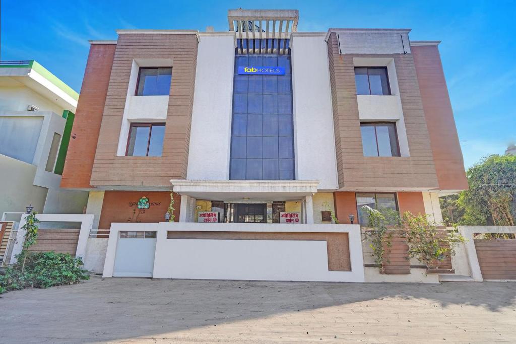 a large building with a white sign in front of it at FabHotel Sandalwood Vibes in Bhopal