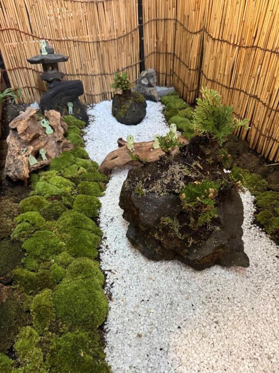 a garden with moss and rocks and a japanificialificialificialificialificialificial at Kyoto151 in Kyoto