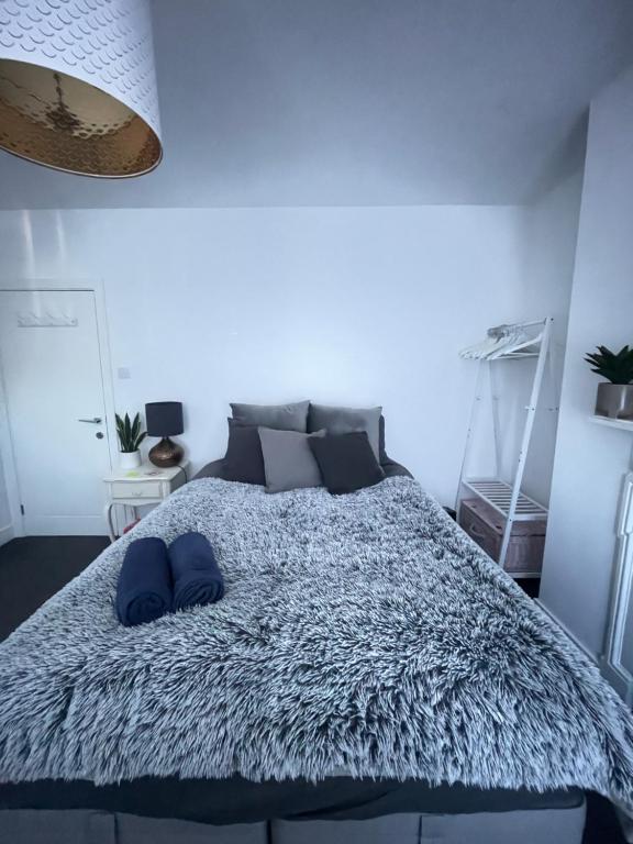 a bedroom with a large bed with blue pillows on it at Artsy Minimalist Suite in Southend-on-Sea