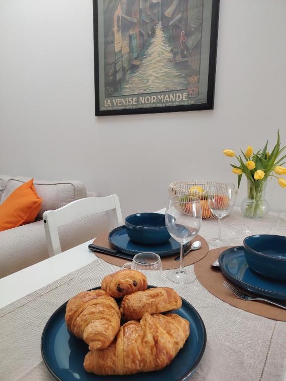 a table with two plates of pastries on it at Appartement rénové centre Pont-Audemer-calme, Wi-Fi, proche Honfleur in Pont-Audemer