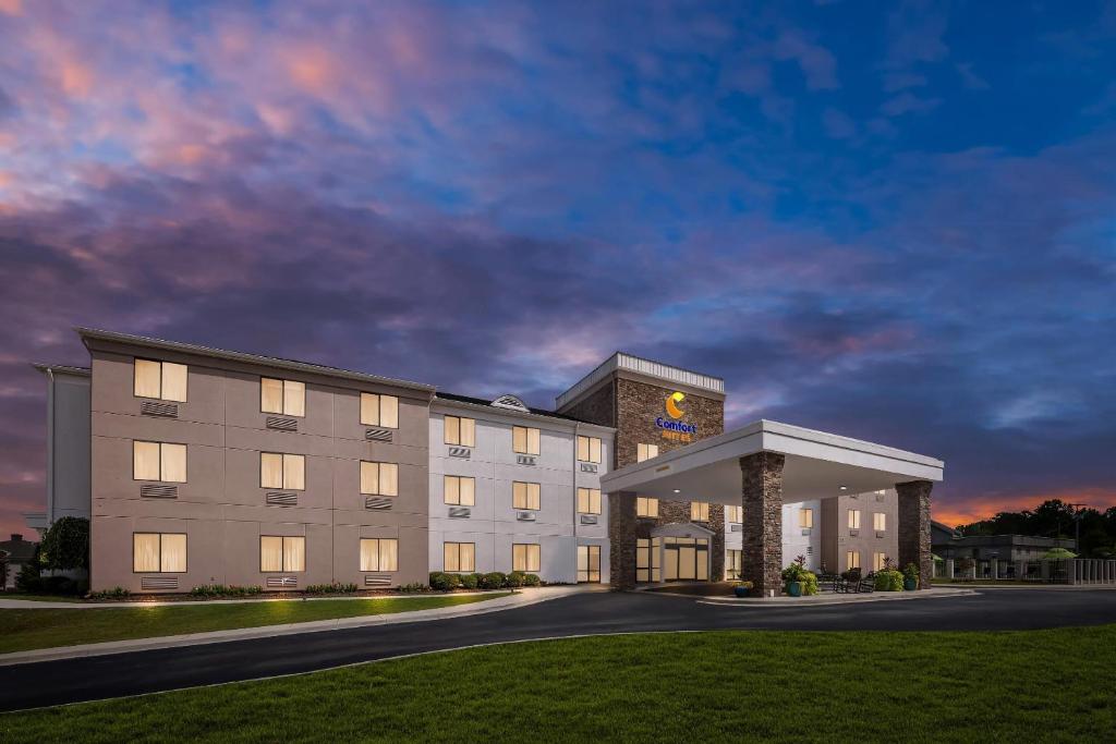 a large white building with a clock tower at Comfort Suites Cullman I-65 Exit 310 in Cullman