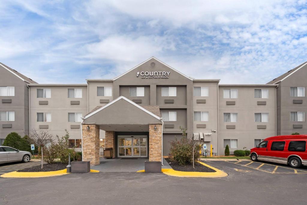 a large building with a van parked in a parking lot at Country Inn & Suites by Radisson, Fairview Heights, IL in Fairview Heights